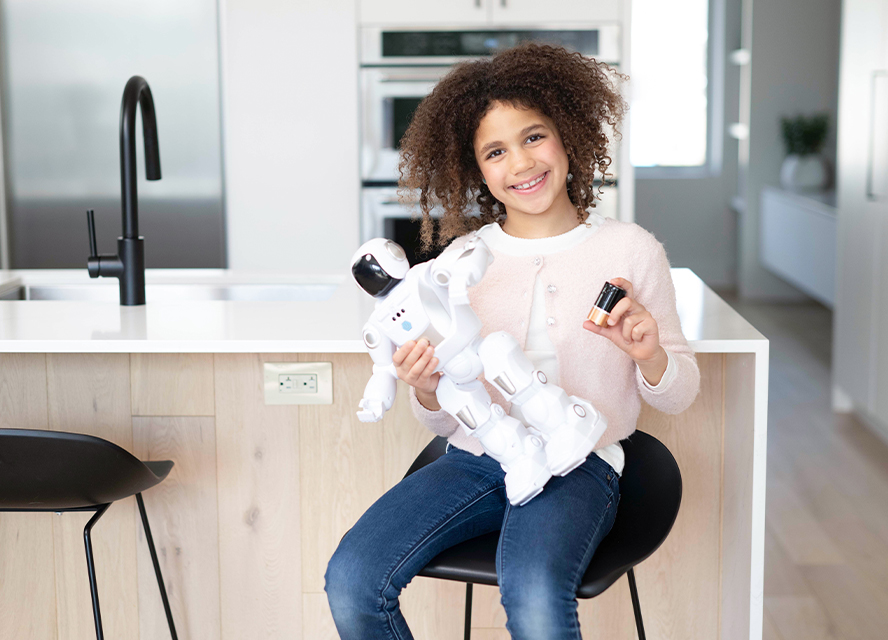 Girl collecting battery from robot toy