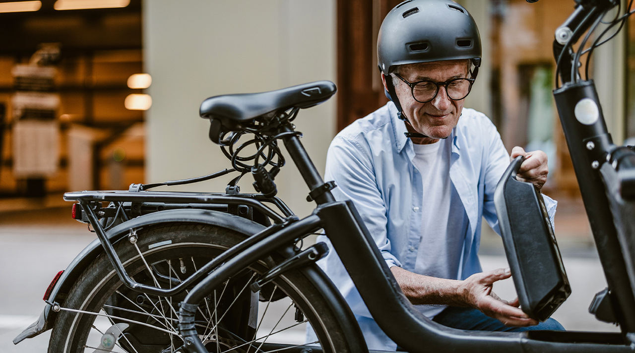 Man removing electric battery from bike